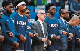  ?? JESSICA HILL/AP PHOTO ?? UConn men’s basketball coach Dan Hurley stands with players during the national anthem before a game last season, Hurley’s first with the Huskies, in Hartford.