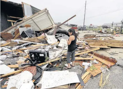  ?? David J Phillip ?? > Resident Jennifer Bryant looks over the debris from her family business destroyed by Hurricane Harvey over the weekend in Katy, Texas