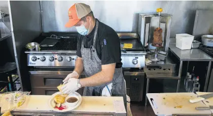  ?? KRISTEN ZEIS/STAFF ?? Rodrigo Ochoa prepares barbacoa quesadilla at Chorizo Mexican restaurant in Norfolk in June.