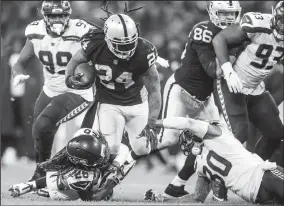  ?? BETTINA HANSEN/TRIBUNE NEWS SERVICE ?? Oakland Raiders running back Marshawn Lynch is stopped by Seattle Seahawks cornerback Shaquill Griffin and strong safety Bradley McDougald in the second half on Sunday at Wembley Stadium in London.