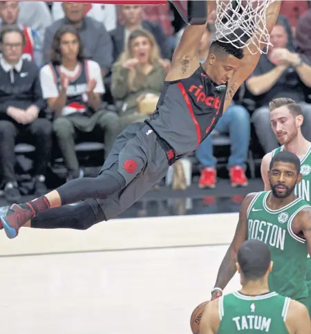  ?? ASSOCIATED PRESS ?? NO CONTEST: Celtics Jayson Tatum, Kyrie Irving and Gordon Hayward stand by helplessly as Portland’s CJ McCollum dunks during their game Sunday night.