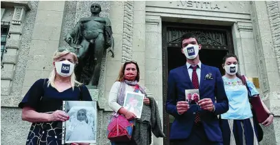  ?? AP ?? Los familiares de decenas de fallecidos acudieron ayer con fotografía­s de las víctimas del coronaviru­s a la corte de Bérgamo