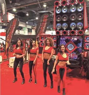  ?? EDWARD C. BAIG/USA TODAY ?? Ivette Flores, right, and other models are paid $250 a day to drum up business at the Orion Car Audio booth.