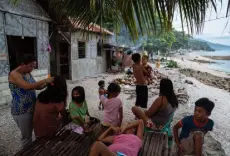  ?? Photos by Hannah Reyes Morales, © The New York Times Co. ?? Families hang out on a beach in Tan-awan.