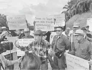  ??  ?? HENTIKAN SEGERA: Tuai Rumah Marepat Sekeran dari Sebungan bersama ketua masyarakat lain ketika ditemui semalam.