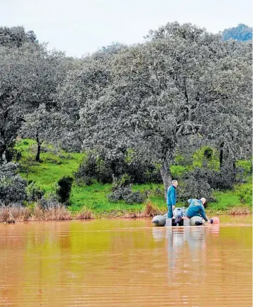  ?? ?? Dos agentes del GEAS colocan boyas en el lago para una inspección