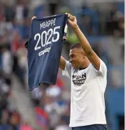  ?? (AFP) ?? Paris Saint-Germain's Kylian Mbappe poses with a jersey after announcing his stay at the club until 2025