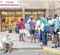  ??  ?? People line up to enter a hurricane shelter at Trask Middle School in North Carolina. — AFP photo