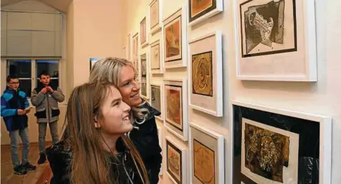  ??  ?? Die Schleizer Gymnasiast­in Mirja Rausch schaut sich mit ihrer Mutter Yvonne Rausch ihr Fossil-bild an, das in der Wanderauss­tellung namens Bildberühr­ung zu sehen ist. Diese wurde auf Schloss Burgk eröffnet. Fotos (): Peter Cissek