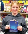  ?? (NWA Democrat-Gazette/ Annette Beard) ?? Klassy Whitlow, a sixth-grade student at Pea Ridge Middle School, spent her own money to buy books for fellow students during the book fair at the school.