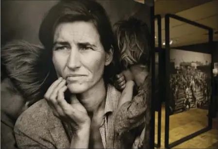  ?? AP PHOTO ?? In this photo taken May 11 the iconic photograph Migrant Mother looks out at the exhibit "Dorothea Lange: Politics of Seeing," at the Oakland Museum of California in Oakland.
