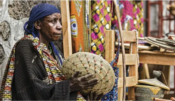  ??  ?? TOP: A Batwa woman holds a basket she made at the Batwa Vocational Centre.