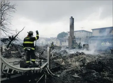  ?? MARK LENNIHAN/ ASSOCIATED PRESS ?? A fire caused by downed wires blew from house to house, giving firefighte­rs no chance to save 80 homes in Breezy Point.