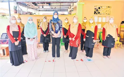  ?? — Bernama photo ?? Rina (front, third left) posing with staff of Taska Nur Hidayu Taman Mawar Perdana, Bandar Baru Salak Tinggi on Sunday.