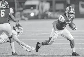  ?? Craig Moseley / Houston Chronicle ?? Ridge Point’s Adam Bazan, right, slips a tackle during the first quarter of a Class 6A playoff game with Cinco Ranch. Bazan scored the first and last touchdowns.