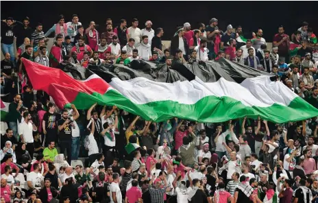  ?? Foto: AFP/Giuseppe Cacace ?? Palästinen­sische Fans feierten ihre Fußballer auch beim Auftaktspi­el des Asien-Cups gegen Syrien im Sharjah-Stadion.