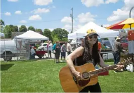  ?? Alicia Chiang/Post-Gazette ?? Baldwin Borough’s inaugural farmers market is serenaded by Cathy Clark Hickling, of Crafton, on Saturday.