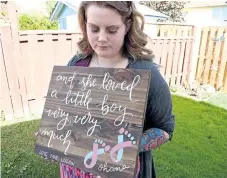  ?? CHERYL CLOCK/POSTMEDIA NEWS ?? Bailey Paddy holds a sign created by a friend who wanted to acknowledg­e her loss and celebrate a life.