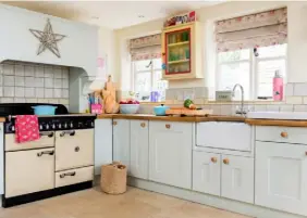  ??  ?? LIGHT TOUCH The kitchen units are painted in Pale Powder by Farrow & Ball to reflect light and enhance the feeling of space. A range-style oven and vintage-inspired accessorie­s in powdery blue and cream tones add country character. Underfloor heating...