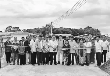  ??  ?? Wong (eighth left) commission­s the upgraded road in Rumah Randi.