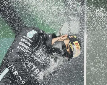  ??  ?? 0 Lewis Hamilton celebrates on the podium after winning the Portuguese Grand Prix in Portimao