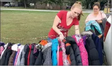  ?? Photo by Tina Crose ?? Parents found a good selection of warm coats to choose from at the coat giveaway sponsored by Imagine Before and After School Care in Gravette on Oct. 15.