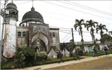  ?? TED ALJIBE/AFP ?? Philippine Marines walk past a mosque during a patrol along a deserted street at the frontline in Marawi, on the southern island of Mindanao on Saturday.