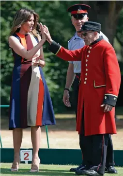  ??  ?? Give me five! The First Lady with a Chelsea Pensioner