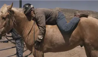  ??  ?? Inmate Robert Raley hugs Hijack as part of the Wild Horse Program inside Northern Nevada Correction­al Center.