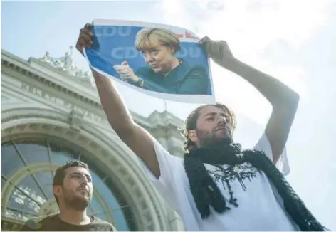  ??  ?? Des migrants rendent hommage à Angela Merkel, Budapest, 4 septembre 2015.