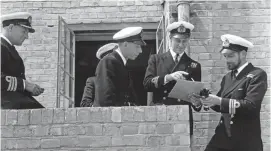  ??  ?? Lieutenant Philip Mountbatte­n, (second from right) prior to his marriage to Princess Elizabeth, talking to a group of naval officers on his return to Royal Navy duties, at the Petty Officers Training Centre on 31 July 1947