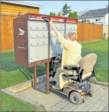  ?? SUBMITTED PHOTO ?? Linda Crabtree reaches for a community mailbox from her motorized scooter.