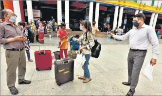  ?? SONU MEHTA/HT PHOTO ?? A passenger, upon arriving at the New Delhi railway station, sprays disinfecta­nt over the luggage of his family members. n