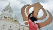  ?? PTI ?? A worker carries the Sikh religious emblem ‘khanda’ outside the n Golden Temple in Amritsar on Tuesday.