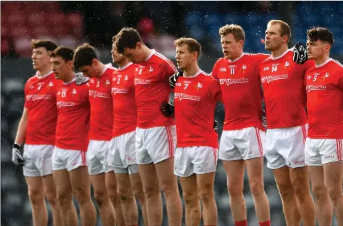  ??  ?? Louth players stand for a minute’s silence in memory of the late Liam Miller at Pairc Ui Rinn on Sunday.