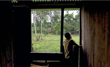  ?? FERNANDA PINEDA/ WASHINGTON POST ?? Breiner Tijaro, 11, waits for the rain to stop in Montebello, Colombia.