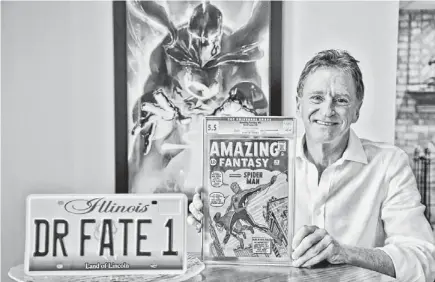  ?? M. SPENCER GREEN/AP ?? Steve Landman shows one of his collectabl­e comic books, a vanity license plate with the name of a childhood superhero on it, and a poster of the same superhero at his home in Kildeer, Ill.