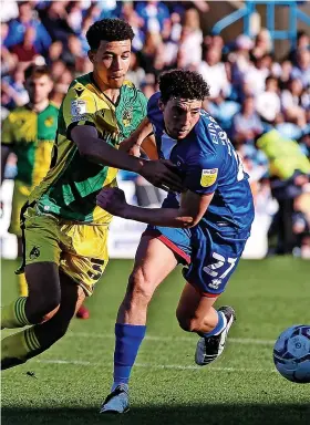  ?? ?? Luca Hoole challenges Carlisle’s Jordan Gibson for the ball