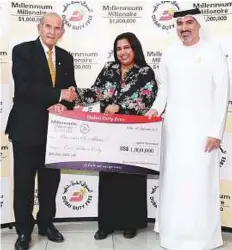  ?? Courtesy: DDF ?? Bronvin S. Muns receives her Millennium Millionair­e prize from Colm McLoughlin, executive vice-chairman and CEO of DDF, and Salah Tahlak, executive vice-president — Corporate Services.