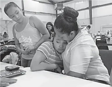  ?? AP Photo/Elliot Spagat ?? n Marta Rivera consoles her 10-year-old daughter, Santo, who sobbed as her mother described feeling anxious about deportatio­n, during a meeting with an immigratio­n advocate Sept. 2 at Emmanuel Baptist Church in Houston. Illegal U.S. immigrants fear...