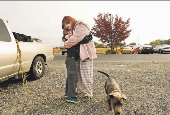  ?? Photograph­s by Carolyn Cole Los Angeles Times ?? JEANNE NEELEY hugs her 10-year-old daughter, Faith, in a parking lot in Oroville. They have been homeless since the Camp fire swept through Berry Creek.
