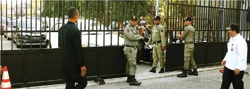  ?? CHUSNUL CAHYADI/JAWA POS ?? AWASI: Kepala Dinas Pol PP Abu Hasan (kanan) memimpin anggotanya menjaga pintu gerbang kantor Pemkab Gresik agar pegawai yang terlambat tidak bisa masuk.