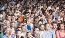  ?? FOTO: THOMAS WARNACK ?? Erinnerung­sfotos und -filme – dann kann man sich zu Hause das Festival noch einmal anschauen.