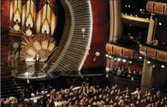  ?? PHOTO BY CHRIS PIZZELLO — INVISION — AP, FILE ?? In this file photo, host Jimmy Kimmel speaks as donuts fall onto the audience at the Oscars in Los Angeles. Cameras never find an empty seat at the Academy Awards, with