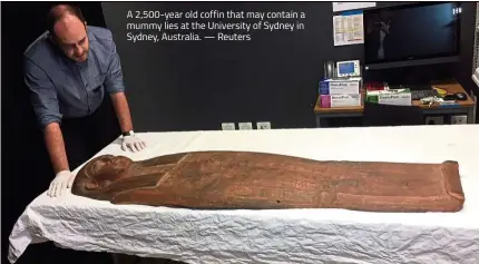  ??  ?? A 2,500-year old coffin that may contain a mummy lies at the University of Sydney in Sydney, Australia. — Reuters