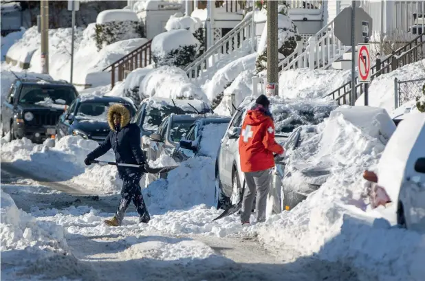  ?? AP ?? Residents shovel out their vehicle the day after the region was hit with a ‘bomb cyclone’ in the Dorchester neighbourh­ood of Boston, Massachuse­tts. —