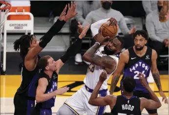  ?? J TERRILL
AP PHOTO/MARK ?? Los Angeles Lakers forward LeBron James, center, tries to shoot as Toronto Raptors forward Freddie Gillespie, left, guard Malachi Flynn, second from left, guard Rodney Hood, second from right, and center Khem Birch defend during the first half of an NBA basketball game Sunday in Los Angeles.