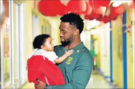  ?? Picture: EUGENE COETZEE ?? MAKING FRIENDS: Springbok flanker Siya Kolisi cuddles little Duwayne Miggels during an impromptu visit to Provincial Hospital in Port Elizabeth in Smile Week. The six-month-old, from Uitenhage, is awaiting an operation on his right foot