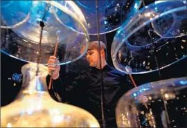  ??  ?? CLOUD CHAMBER BOWLS, among the instrument­s invented by Partch, are played by Dustin Donahue during the dance piece “Daphne of the Dunes.”