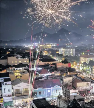  ??  ?? > Fireworks illuminate the city’s skyline during New Year’s Eve celebratio­ns in Yogyakarta, Indonesia